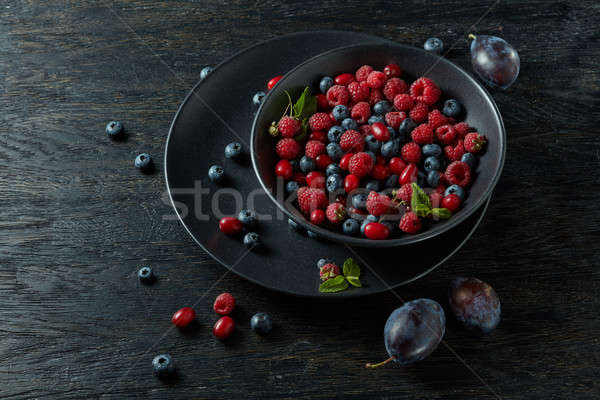 raspberries, blueberries, plum and dogwood. fresh berries on plate Stock photo © artjazz