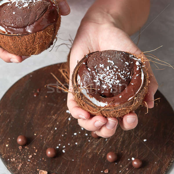 Girl holding and half of coconut shell with chocolate ice cream  Stock photo © artjazz