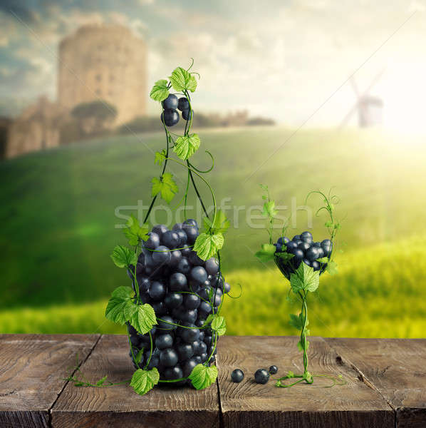 Bottle of Wine and a glass made by of grape leaves and a bunch of grapes on a wooden background Stock photo © artjazz