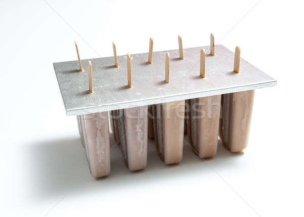 Homemade organic chocolate ice cream lolly in plastic molds with a reflection of shadows on a white  Stock photo © artjazz