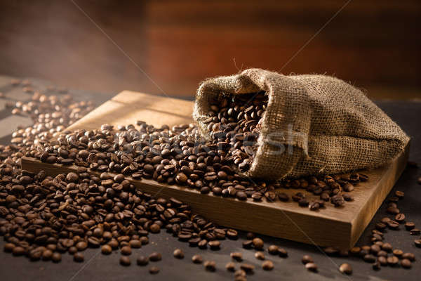 spilled coffee beans in bag on wood Stock photo © artjazz