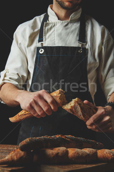 Halved baguette in the hands of a baker Stock photo © artjazz