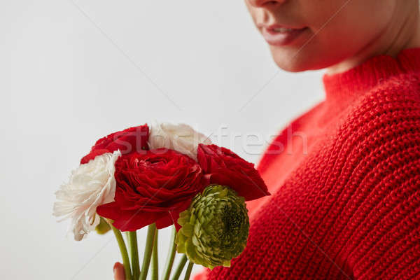 Woman in a red sweatshirt with flowers Buttercup on a white background. Stock photo © artjazz