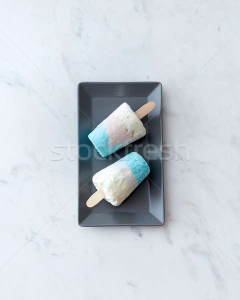 A refreshing sweet ice cream on a stick in a black plate on a gr Stock photo © artjazz