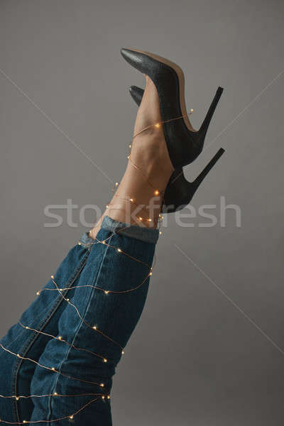 The legs of a woman are stretched out decorated with a Christmas garland Stock photo © artjazz