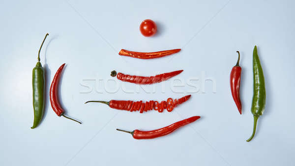 layout of chili peppers and tomato on gray background Stock photo © artjazz