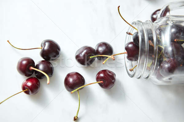 Organic freshly picked red cheries in a glass jar on a kitcen ta Stock photo © artjazz