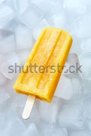Detox, healthy yellow smoothie popsicles over the ice with slice lime and berries, flat lay Stock photo © artjazz