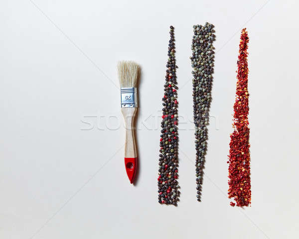 Creative geometric food pattern of fragrant spices - various kinds of pepper and painting brush isol Stock photo © artjazz