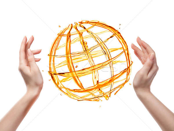 Globe from orange water with human hand isolated on white Stock photo © artjazz