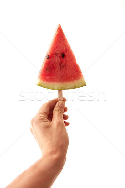 A man's hand holds a juicy piece of watermelon lolly on a white background with space for text. The  Stock photo © artjazz