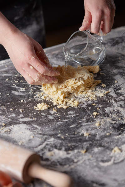 On a kitchen table the women's hands kneads the dough. Step-by-step preparation of the dough Stock photo © artjazz