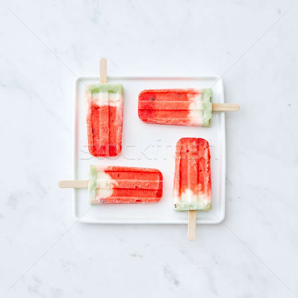 Pattern of ice cream on a stick in the shape of a square on a white plate on a gray marble backgroun Stock photo © artjazz