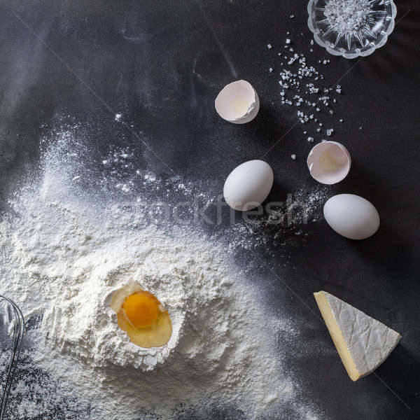 Dough on black table with flour and ingridients Stock photo © artjazz