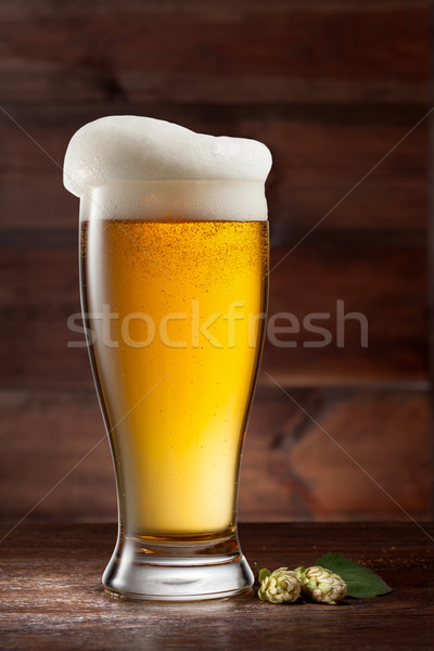 Glass of beer on wood with hop Stock photo © artjazz