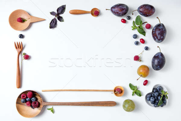 frame of spoons with berries and plums Stock photo © artjazz