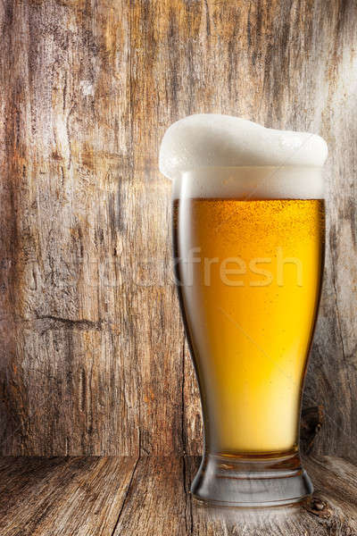 Glass of beer on wooden background Stock photo © artjazz
