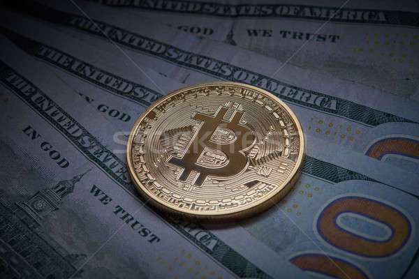 Golden bitcoin Cryptocurrency coin on a pile of US dollars, underground economy and cryptocurrency c Stock photo © artjazz