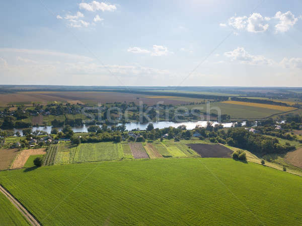Amazing countryscape with green fields, river, greenery and blue cloudy sky in a summer time. Stock photo © artjazz