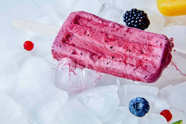 Beet vanilla yogurt popsicle over the ice with berries , flat lay Stock photo © artjazz