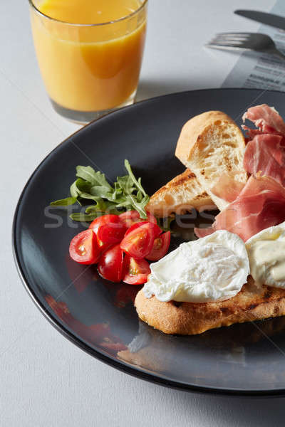 Eggs Benedict with bread and tomato Stock photo © artjazz