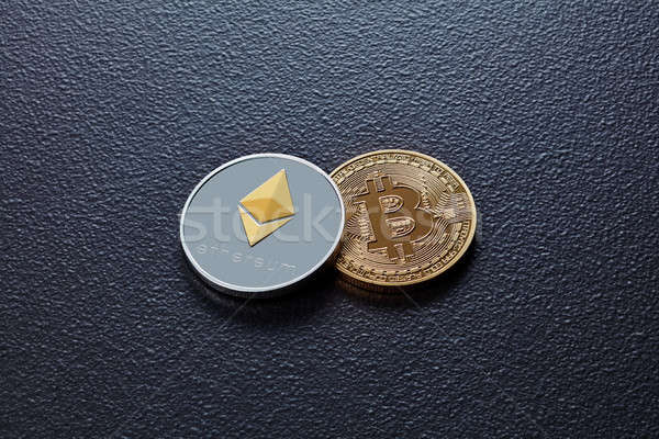 Two coins of crypto currency ETH, BTC on a black concrete background. Business, finance and technolo Stock photo © artjazz