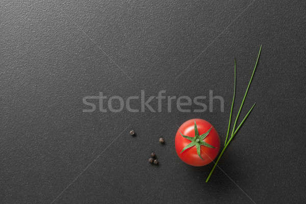 red tomato with green onion on black Stock photo © artjazz
