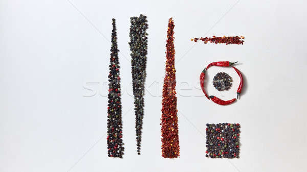 Abstract creative geometric pattern of spices pepper in different forms and pods of red chili pepper Stock photo © artjazz