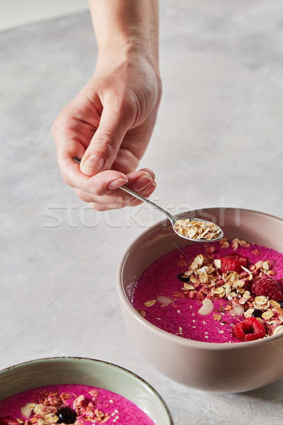Preparing breakfast, the girl's hand puts oatmeal in a fruit smoothie Stock photo © artjazz