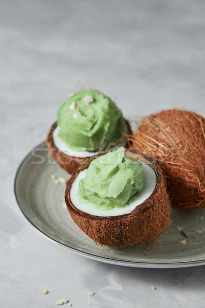 Tasty fresh green fruit ice cream in coconut peel with whole fre Stock photo © artjazz