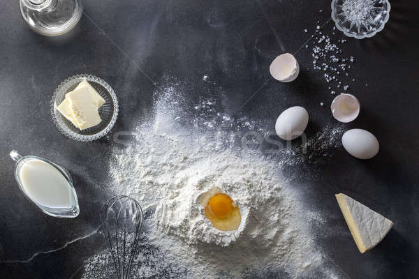 Dough on black table with flour and ingridients Stock photo © artjazz