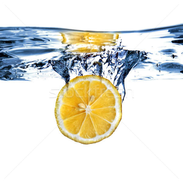 Stock photo: Fresh lemon dropped into water with bubbles isolated on white