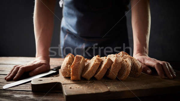 Whole grain bread put on a kitchen plate with a chef, Stock photo © artjazz