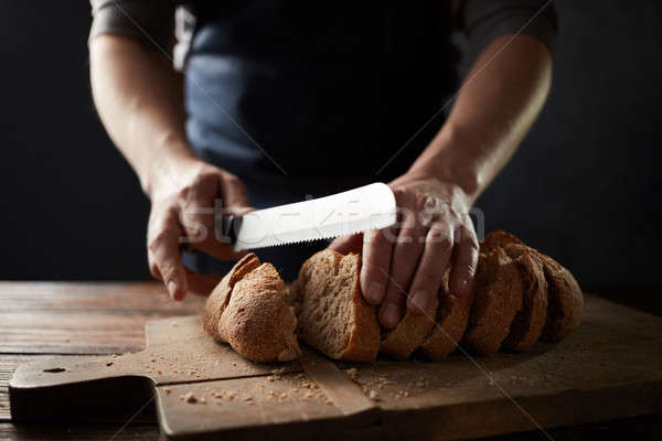 grain bread put on kitchen wood plate with a chef holding knife for cut Stock photo © artjazz