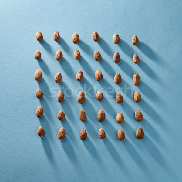 Almonds in a square shape in a blue paper background. Organic food Stock photo © artjazz