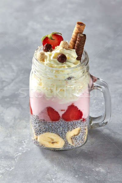 Mason Jar Breakfast. Yogurt with Chia Pudding, snacks and fruits on a concrete background Stock photo © artjazz