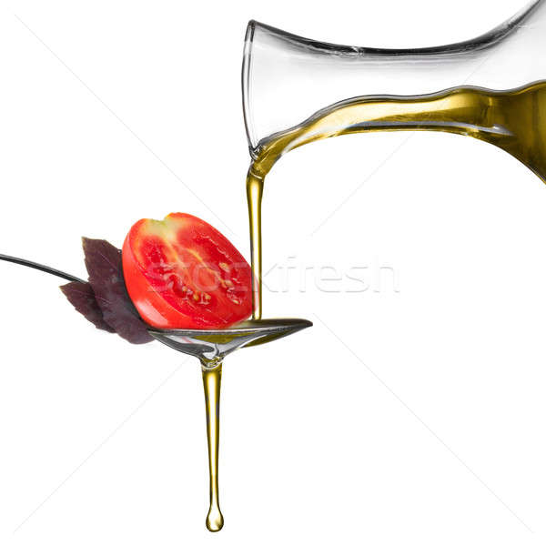 Pouring oil on spoon with basil and tomato isolated on white Stock photo © artjazz