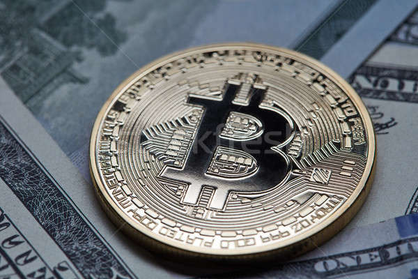 Stock photo: Close-up of gold coin bitcoin on dollar bills