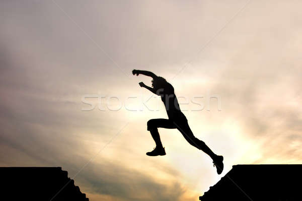 silhouette of jumping boy agains Stock photo © artjazz
