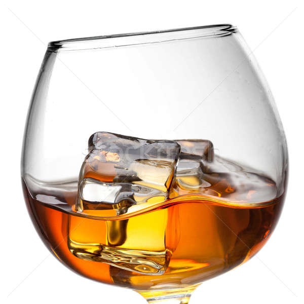 Splash of whiskey with ice in glass isolated on white background Stock photo © artjazz