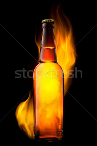 Beer bottle in fire on black Stock photo © artjazz