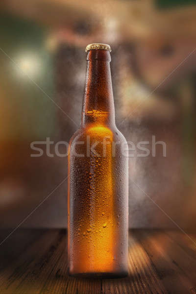 Cold beer bottle with drops, frost and vapour Stock photo © artjazz