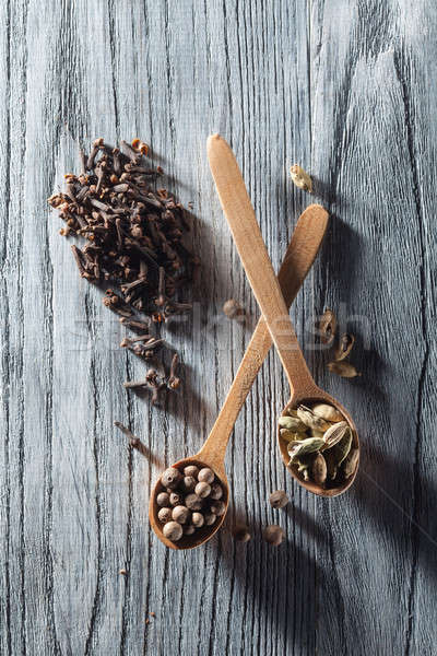 Nutmeg, clove and allspice in old spoon on wooden table Stock photo © artjazz