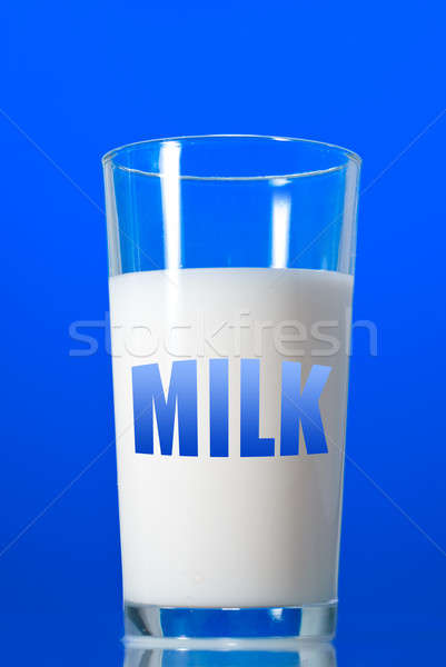 Milk in glass isolated on blue Stock photo © artjazz