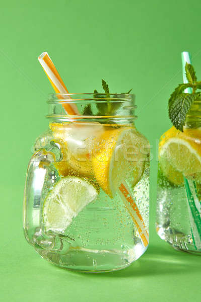 Summer refreshing detox drink for diet in the glass jars on a green background. Concept of healthy d Stock photo © artjazz