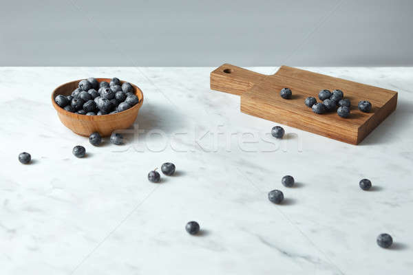 Summer organic natural sweet blueberries in a wooden plate, board on a white with copy space. Stock photo © artjazz