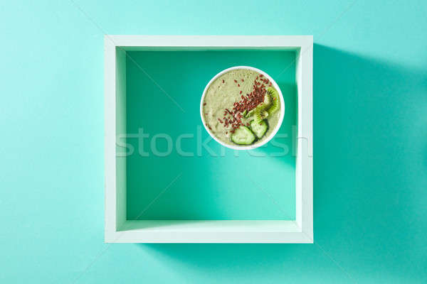 Healthy smoothie from green vegetables and fruits with flax seeds in a white bowl in square frame on Stock photo © artjazz
