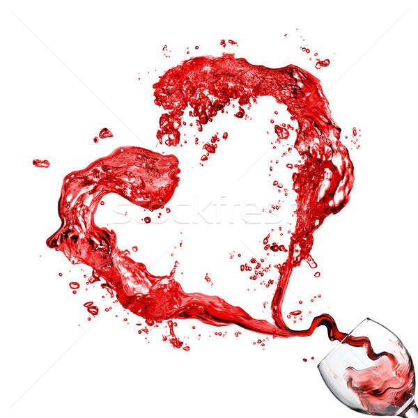 Heart from pouring red wine in glass goblet isolated on white Stock photo © artjazz