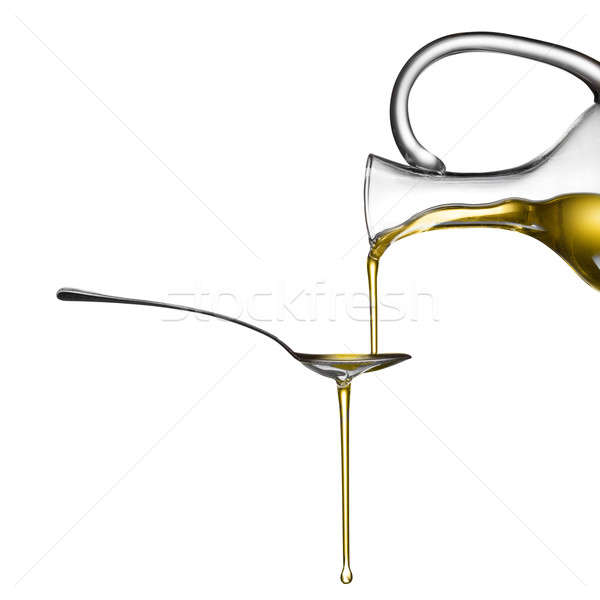 Pouring oil on spoon isolated on white Stock photo © artjazz
