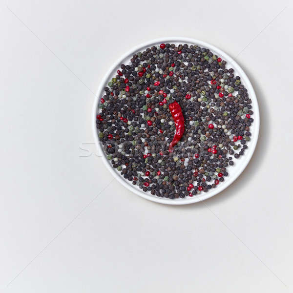 Colorful decorative pattern of species various kinds of peper and pod of red chili pepper on a white Stock photo © artjazz